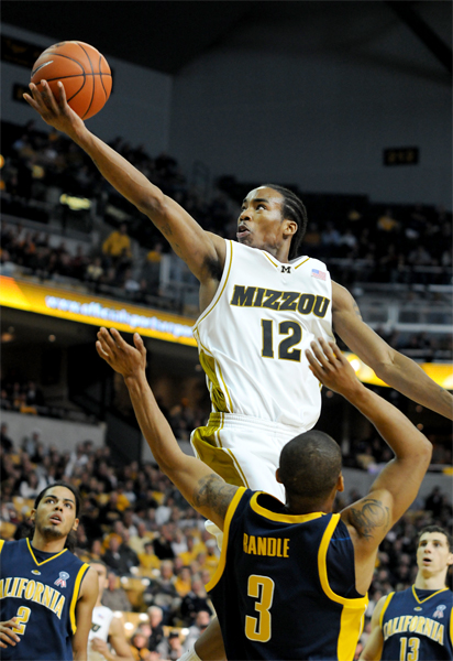 Basketball player goes for a shot.